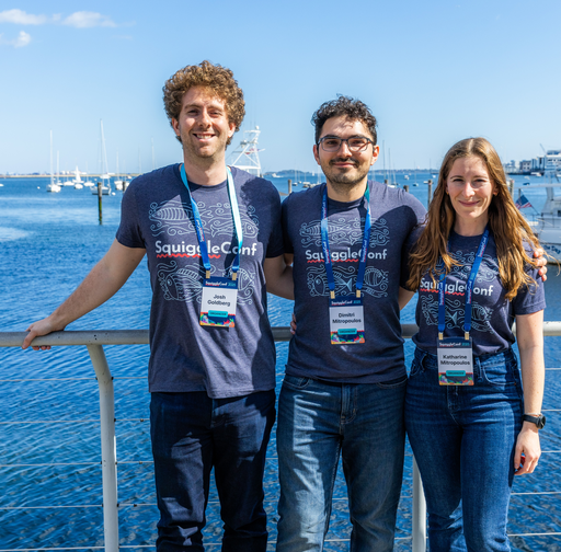 Smiling photo of Dimitri and Katharine and me in SquiggleConf 2025 shirts at the Boston harbor