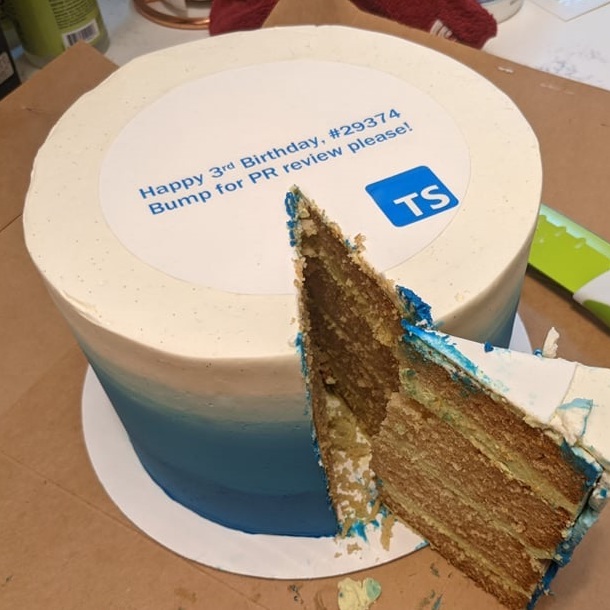 Fancy blue and white circular cake with text 'Happy 3rd Birthday, #293374' and 'Bump for PR review please!' above the TypeScript logo